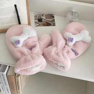 Detailed view of pink plush mittens with white bone accent and purple letter W embroidery