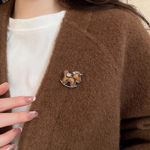 Detail of a rocking horse brooch with brown enamel finish and small rhinestones