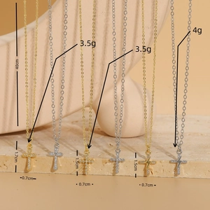 Cross and lightning bolt zircon necklaces in gold and silver finish on display