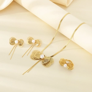 Detailed view of golden butterfly jewelry set with pearls and elegant tassel chains