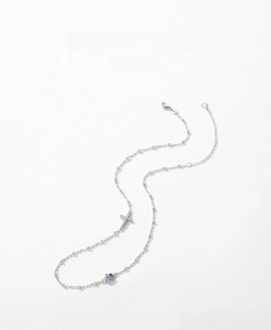 Macro shot of S925 silver necklace with micro-pave cross and blue evil eye charms