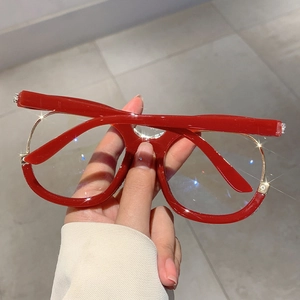 Detailed view of red oversized frames with double-row rhinestones and metal accents