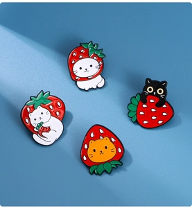 Detail of four creative strawberry cat enamel pins with colorful alloy paint finish