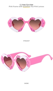 Close-up of pink heart-shaped sunglasses with sparkling rhinestones and gradient lenses
