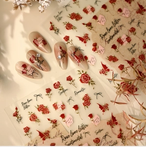 Detail of French rose nail stickers with red flowers and black bows on gradient nails