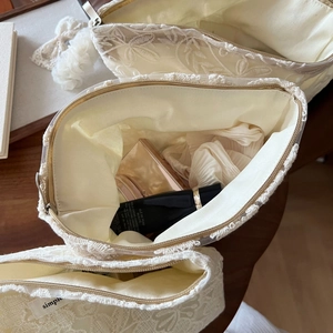 Détail d'une trousse à maquillage en dentelle française avec fermeture éclair en métal