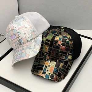 Close-up of sparkling rainbow sequins and breathable mesh fabric on stylish baseball caps