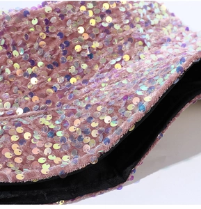 Dettaglio macro della texture in camoscio rosa con paillettes colorate e fodera interna