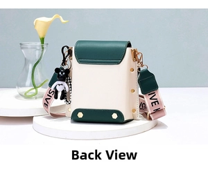 Detail view of the back of a mini beige and green leather bucket bag with jacquard strap