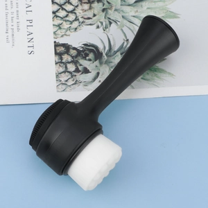 Detailed view of dual-sided facial brush with soft white bristles and black silicone pad