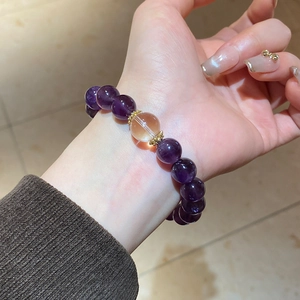 Detailed shot of purple amethyst beaded bracelet with amber accent on wrist