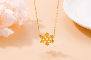 Macro detail of gold snowflake necklace pendant on a warm warm background