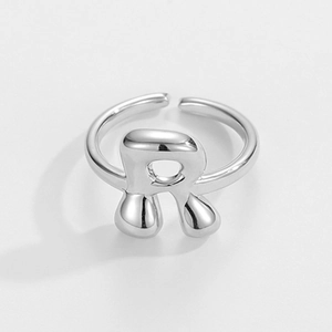 Nahaufnahme des verstellbaren silbernen Buchstabe-R-Rings mit geschmolzener Metallstruktur