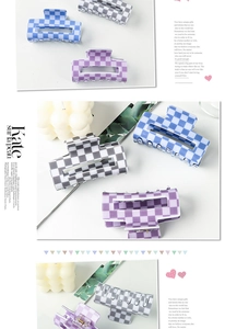 Détail de pinces à cheveux rectangulaires à damier en bleu, violet et gris avec ressort