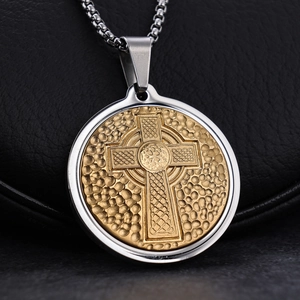 Celtic cross pendant necklace in two-tone silver and gold stainless steel on a black stand