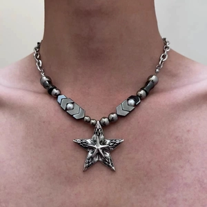 Macro shot of Y2K gothic star pendant with silver and black beaded chain on neck