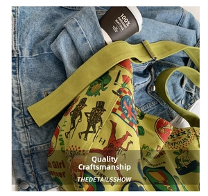 Detail of vintage green canvas tote with retro prints on blue denim background