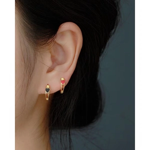 Detail of s925 silver gold-plated heart hoop earrings worn on a model's ear