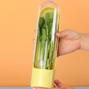 Detail showing hand holding a yellow herb saver with clear lid keeping greens fresh