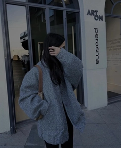Macro shot of grey oversized wool coat texture with a brown shoulder bag in city street