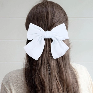 Elegant large white satin bow hair clip accessory worn on back of model's head