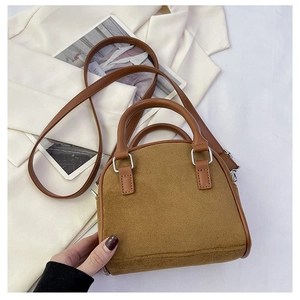 Close-up of brown suede and leather handbag with silver hardware and dual handles
