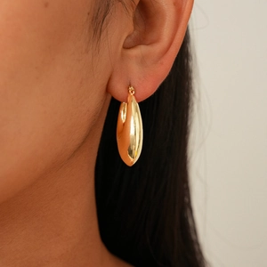 Macro shot of polished gold teardrop earrings showing the glossy mirror finish