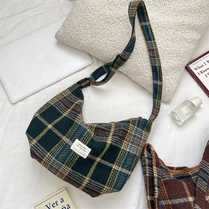 Macro detail of plaid tweed crescent bag with classic green and yellow tartan pattern