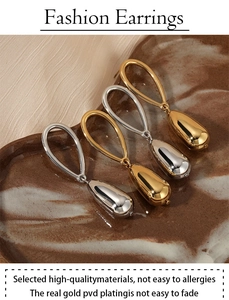Detail of PVD gold and silver teardrop earrings with anti-allergy features on tray