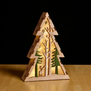 Macro detail of wooden Christmas tree LED light with laser-cut deer and forest scene