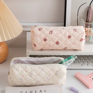 Quilted fabric pencil cases with bear and rabbit prints on a cozy aesthetic desk setup