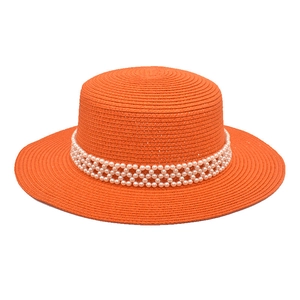 Detail of orange straw boater hat featuring elegant triple-row faux pearl embellishments