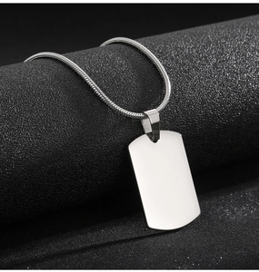 Macro detail of a polished stainless steel rectangular dog tag pendant on a snake chain