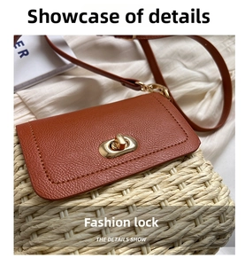 Detail of woven straw shoulder bag featuring brown leather flap and gold metal twist lock