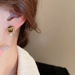 Detail showing vintage round tiger eye stud earrings with a small zircon dangle drop