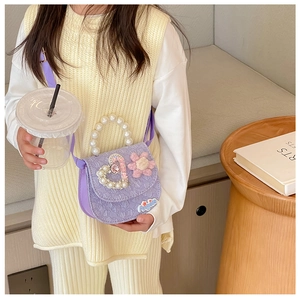 Detail of a purple girl's handbag featuring pearl handles and a cute flower decoration