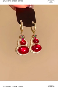 Macro detail of 14k gold plated gourd earrings featuring red resin and sparkling zircons
