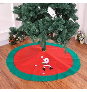 Detail of Christmas tree skirt with wavy green edges and Santa Claus applique decor