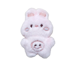 Cute pink plush bunny doll brooch with embroidered smiley face on white background