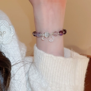 Detailed shot of vintage beaded moon and star bracelet with cat eye stone on wrist