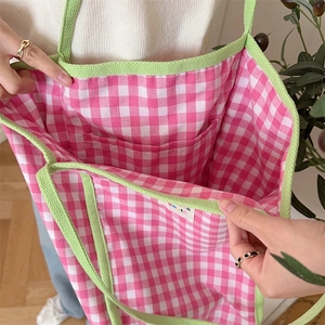 Detail of pink and white checkered canvas tote bag with contrast green lining and inner pocket