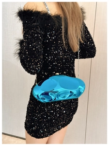 Blue metallic pebble clutch bag with silver chain worn with a black sequin evening dress