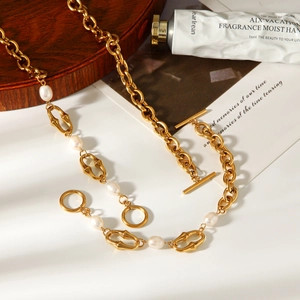 Collana a catena vintage dorata con perle d'acqua dolce e chiusura a T su fondo bianco