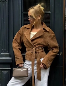 Detail of a brown suede lapel jacket with a waist belt and vintage textures