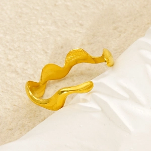 Macro shot of wavy irregular gold ring with adjustable opening on textured background