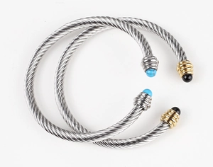 Detail of twisted cable cuff bracelet with turquoise and black bead spherical ends