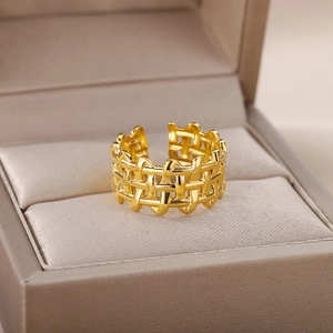 Detailed view of an 18k gold plated woven hollow ring inside a beige jewelry box