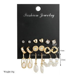 Detail view of 6-pair gold earrings set with pearls and rhinestones on black display card