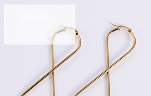 Close-up of polished gold figure-8 steel earrings with a sleek minimalist infinity design