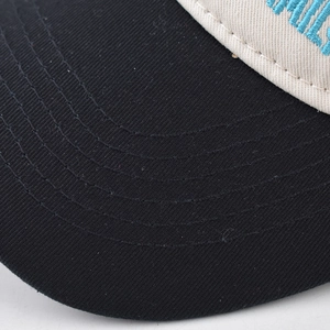 Close-up of baseball cap featuring curved visor stitching and blue embroidery details